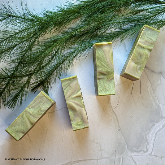 Hand‑cut Still Pines tallow soap bar in a green‑gray hue with natural clay texture and subtle botanical speckling.