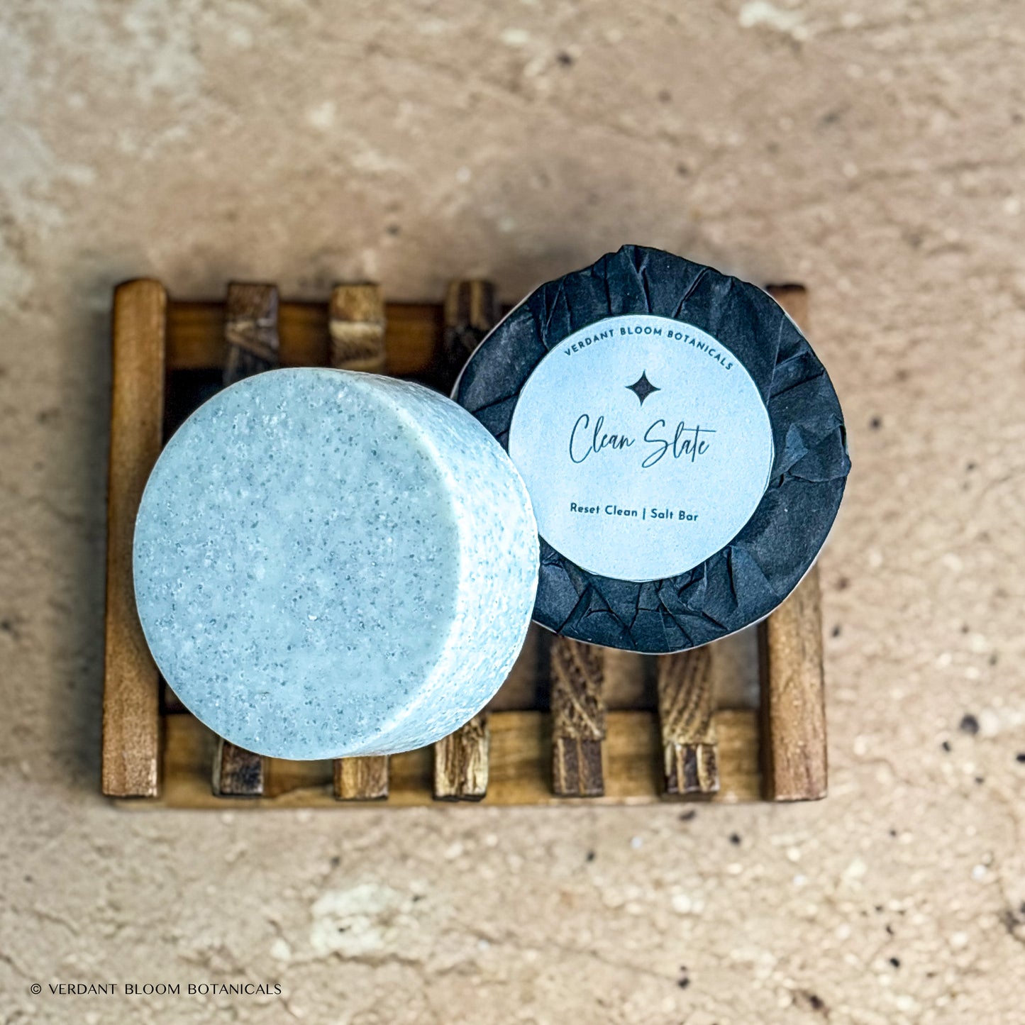 two Clean Slate mini salt bars with label on wooden soap holder