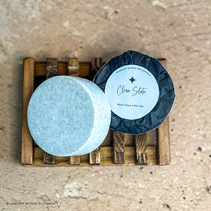 two Clean Slate mini salt bars with label on wooden soap holder
