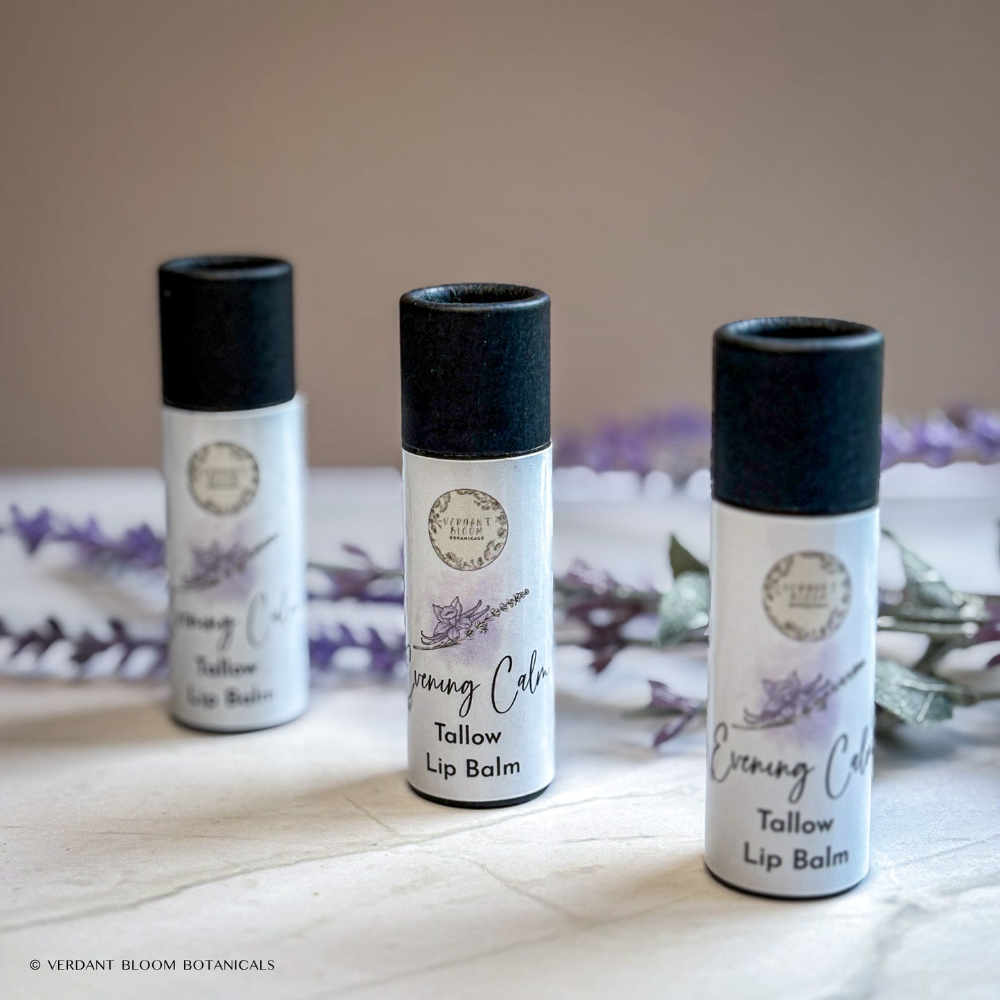 three tubes of Evening Calm lip balm standing next to each other