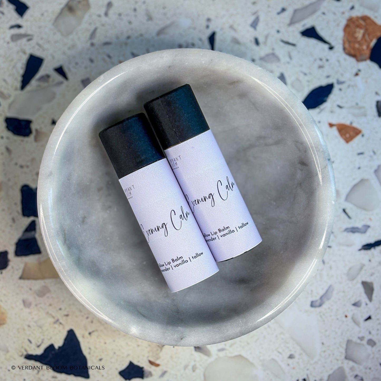 Two tubes of Evening Calm lip balm in bowl