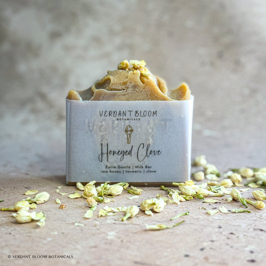 Honeyed Clove soap bar with dried jasmine flowers and label