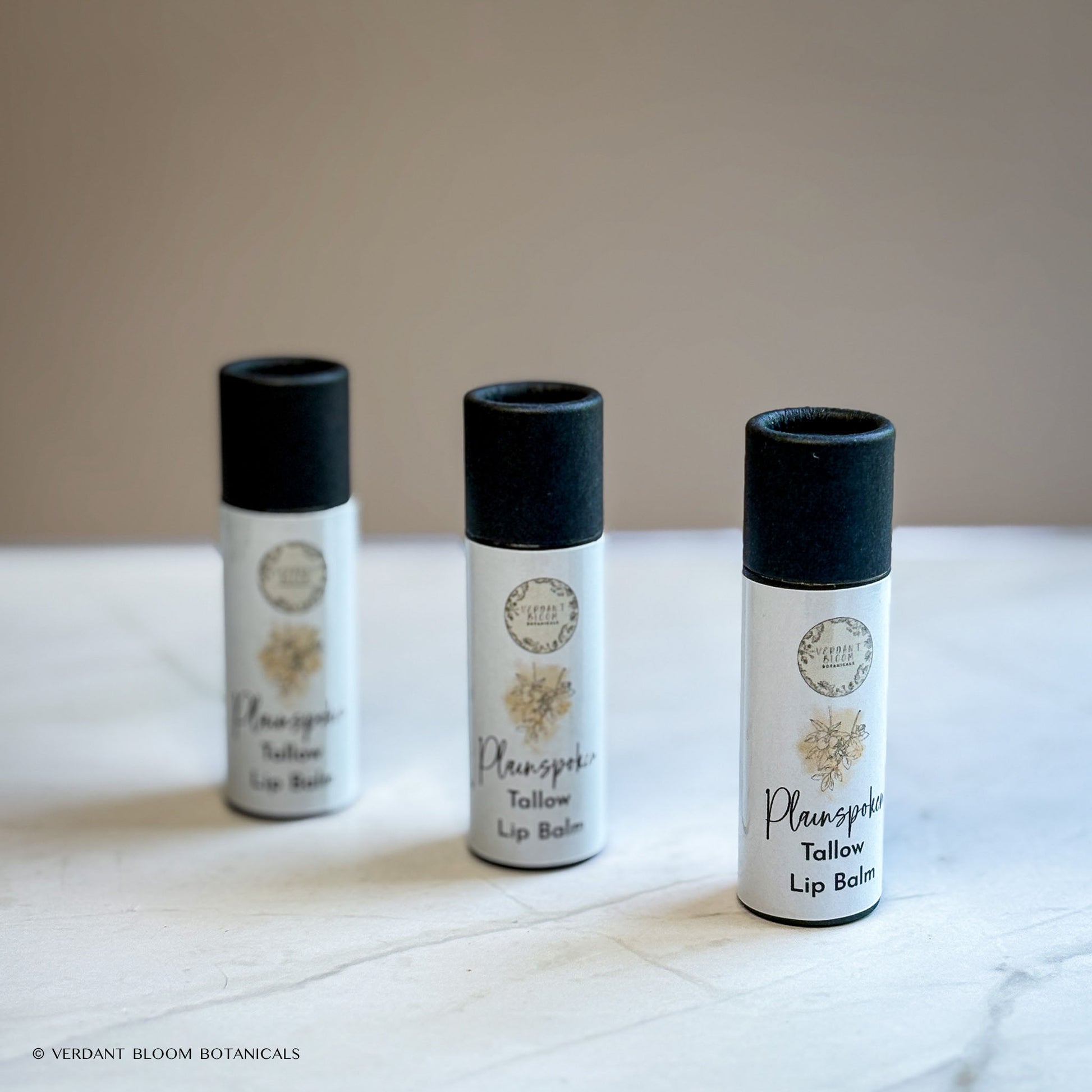 three tubes of Plainspoken lip balm standing next to each other