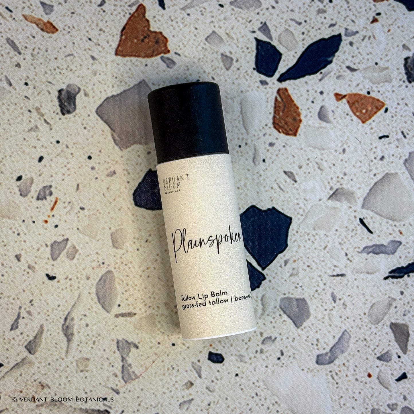 Plainspoken lip balm tube laying on table