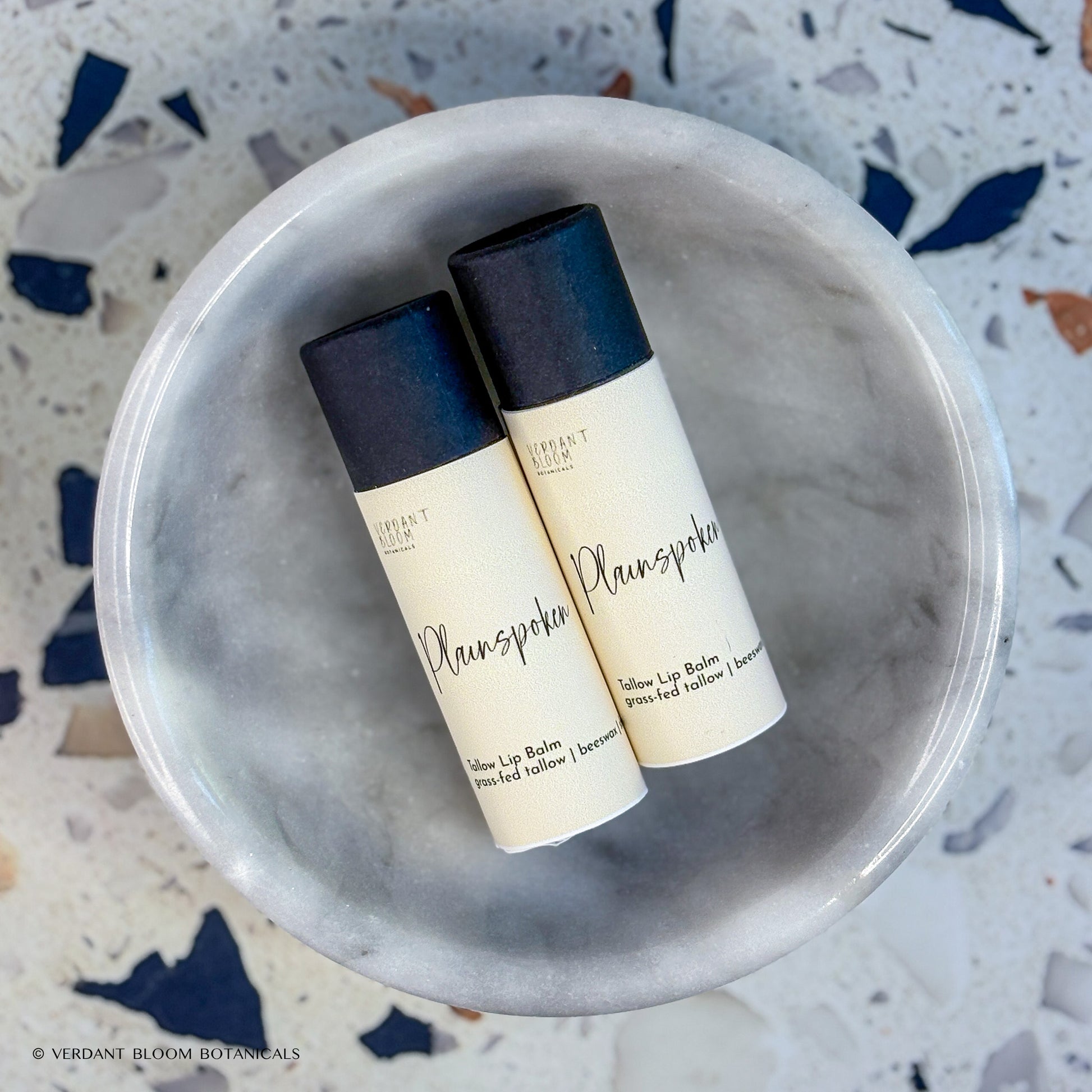 Two tubes of Plainspoken lip balm in bowl