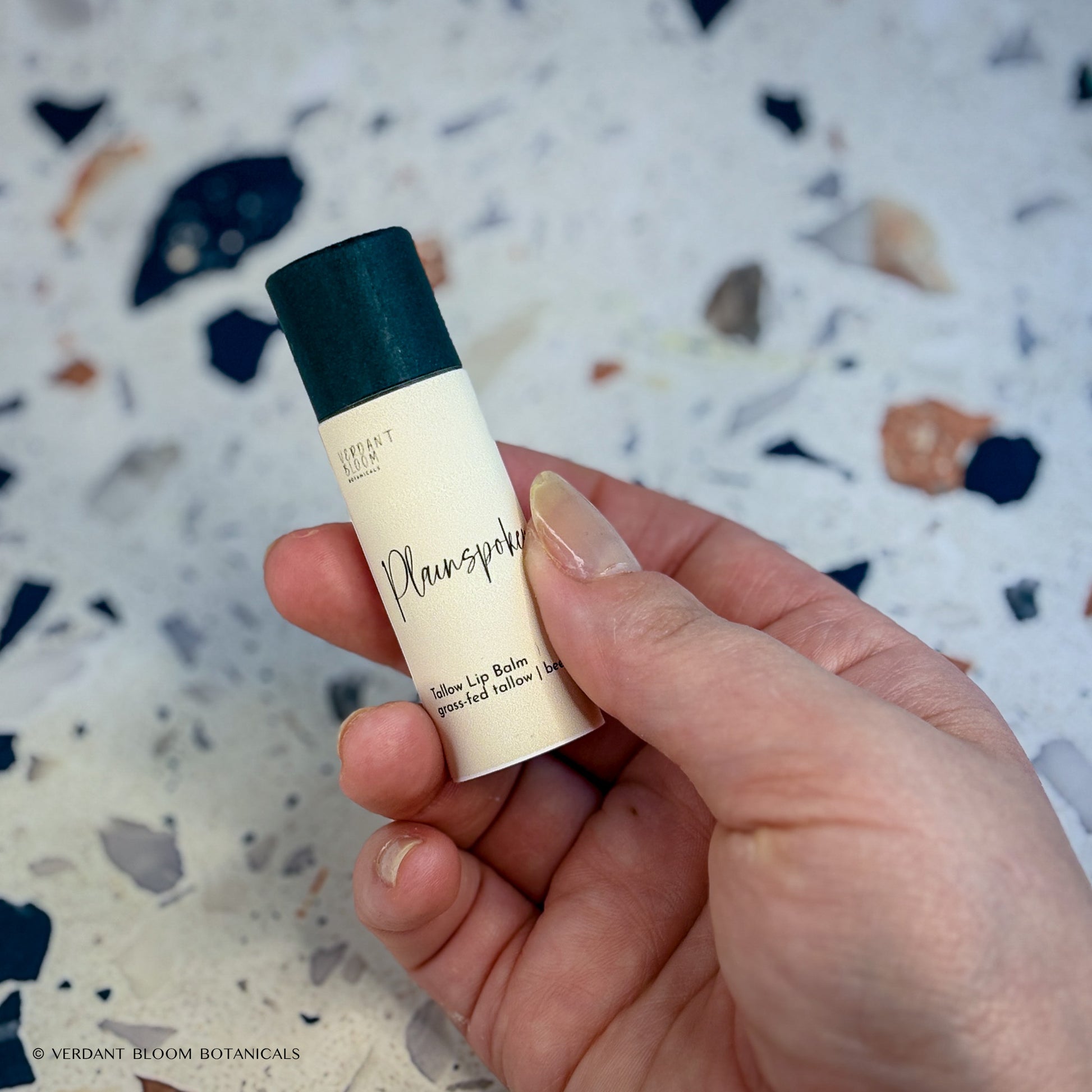 Plainspoken lip balm tube being held in a hand