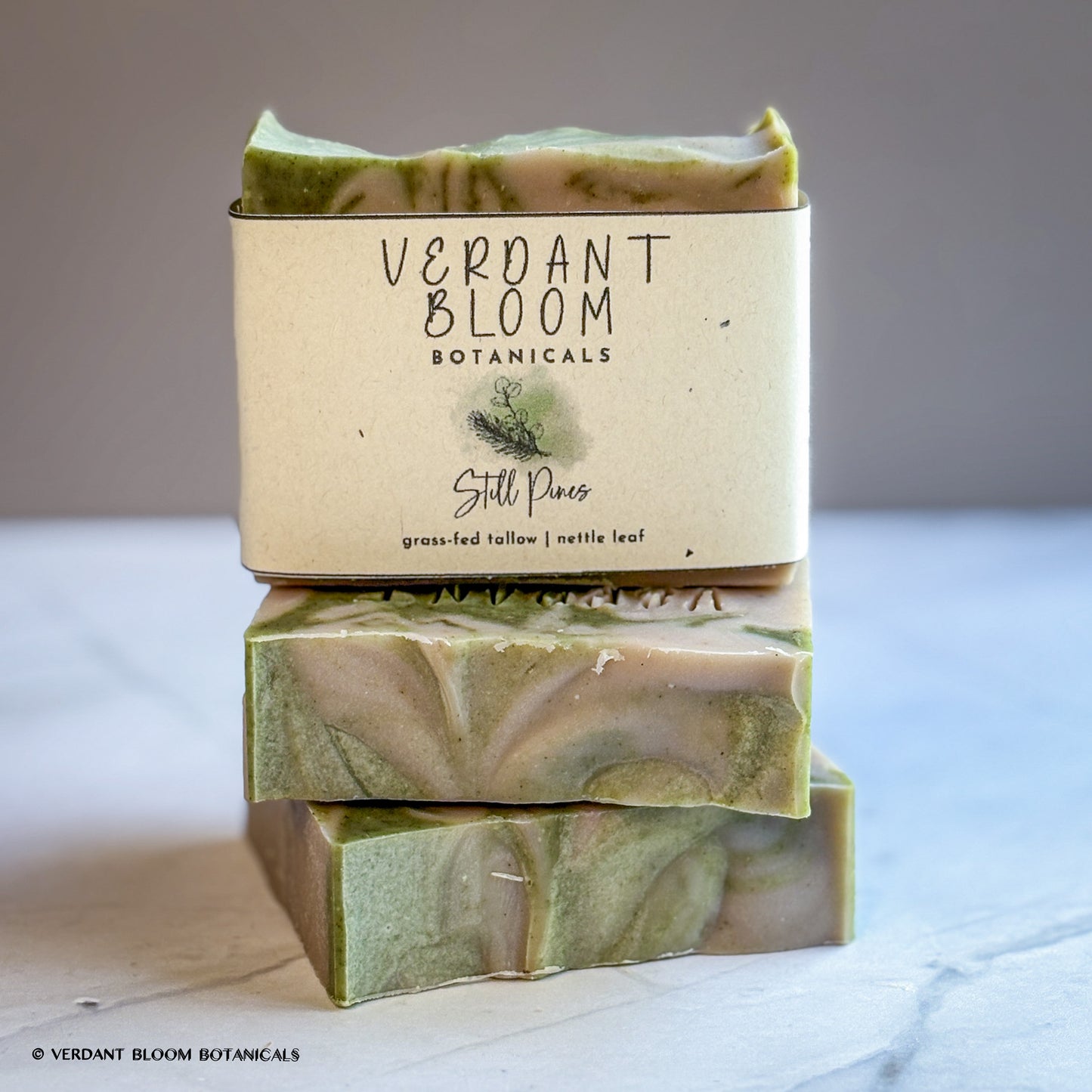 Hand‑cut Still Pines tallow soap bar in a green‑gray hue with natural clay texture and subtle botanical speckling.