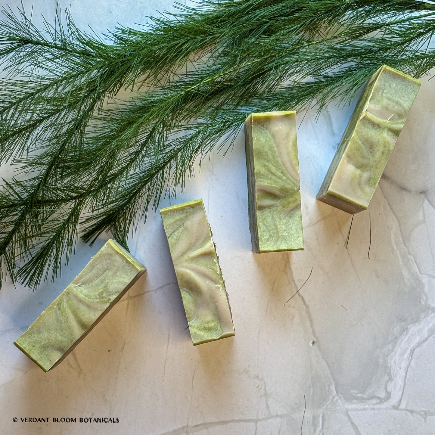 Hand‑cut Still Pines tallow soap bar in a green‑gray hue with natural clay texture and subtle botanical speckling.