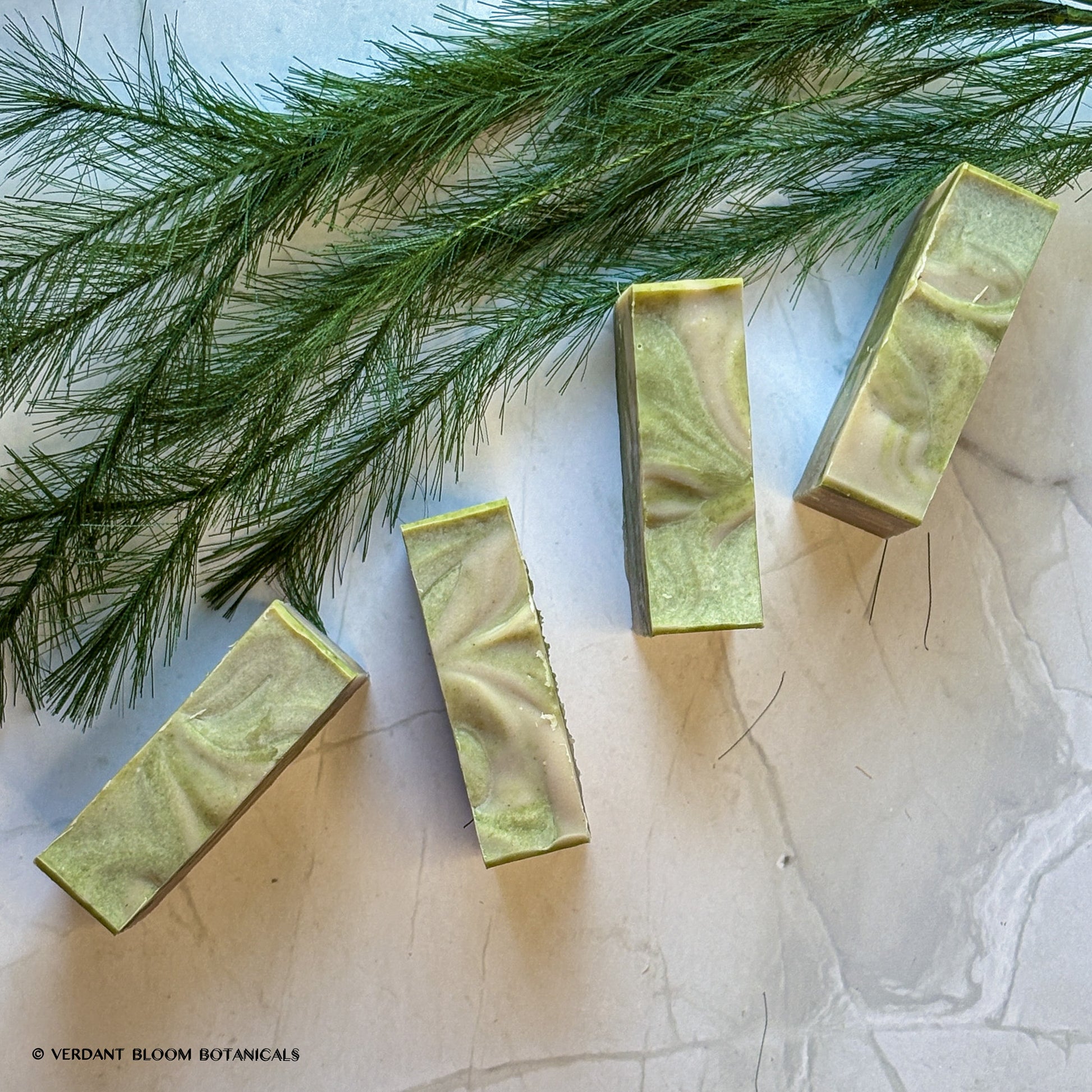 Hand‑cut Still Pines tallow soap bar in a green‑gray hue with natural clay texture and subtle botanical speckling.