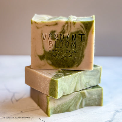 Hand‑cut Still Pines tallow soap bar in a green‑gray hue with natural clay texture and subtle botanical speckling.