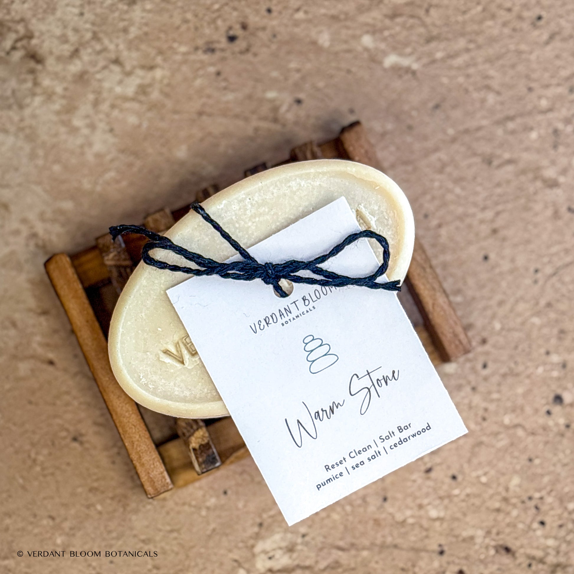 Warm Stone salt bar with label on wooden soap holder