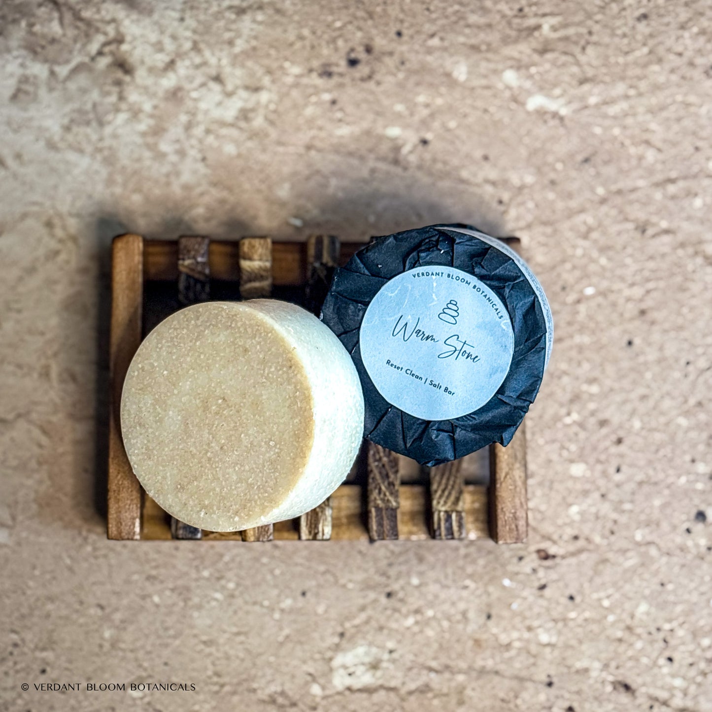two Warm Stone mini salt bars with label on wooden soap holder