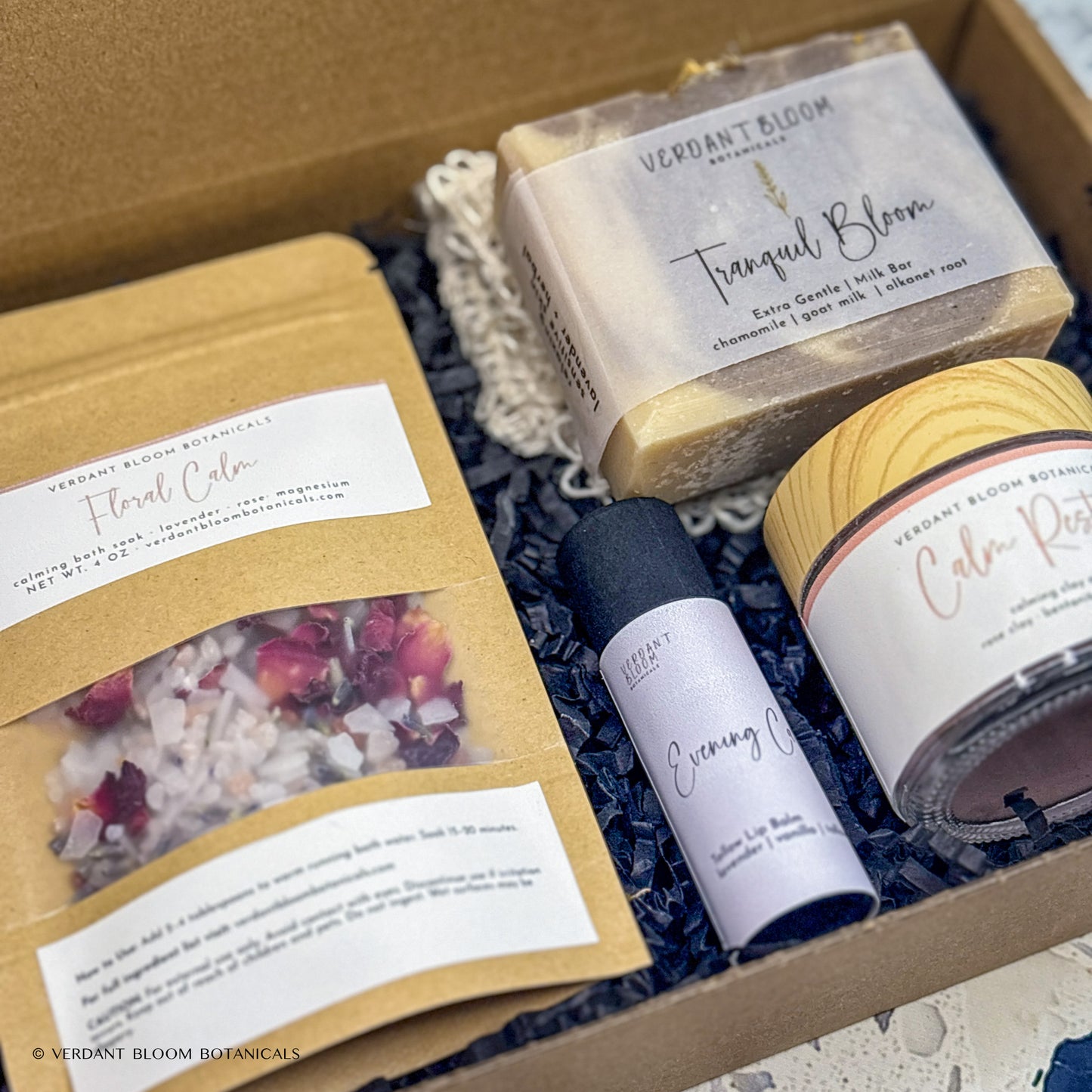 Wind-Down kit containing bath soak, face mask, goat milk soap, lip balm, and sisal soap bag in gift box